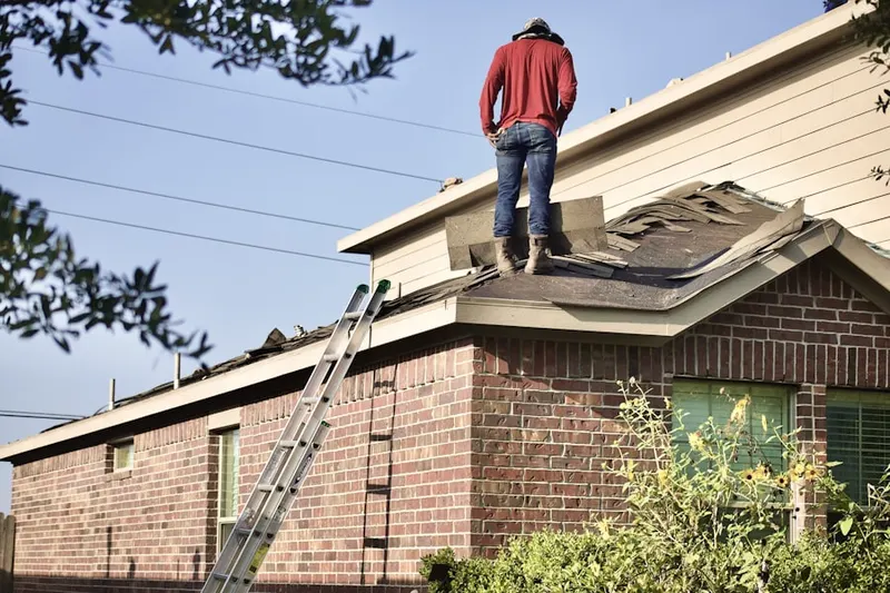 Professional roofer working on a residential roof in Pella